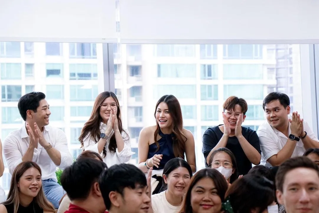 Primal colleagues smiling and applauding together in the office