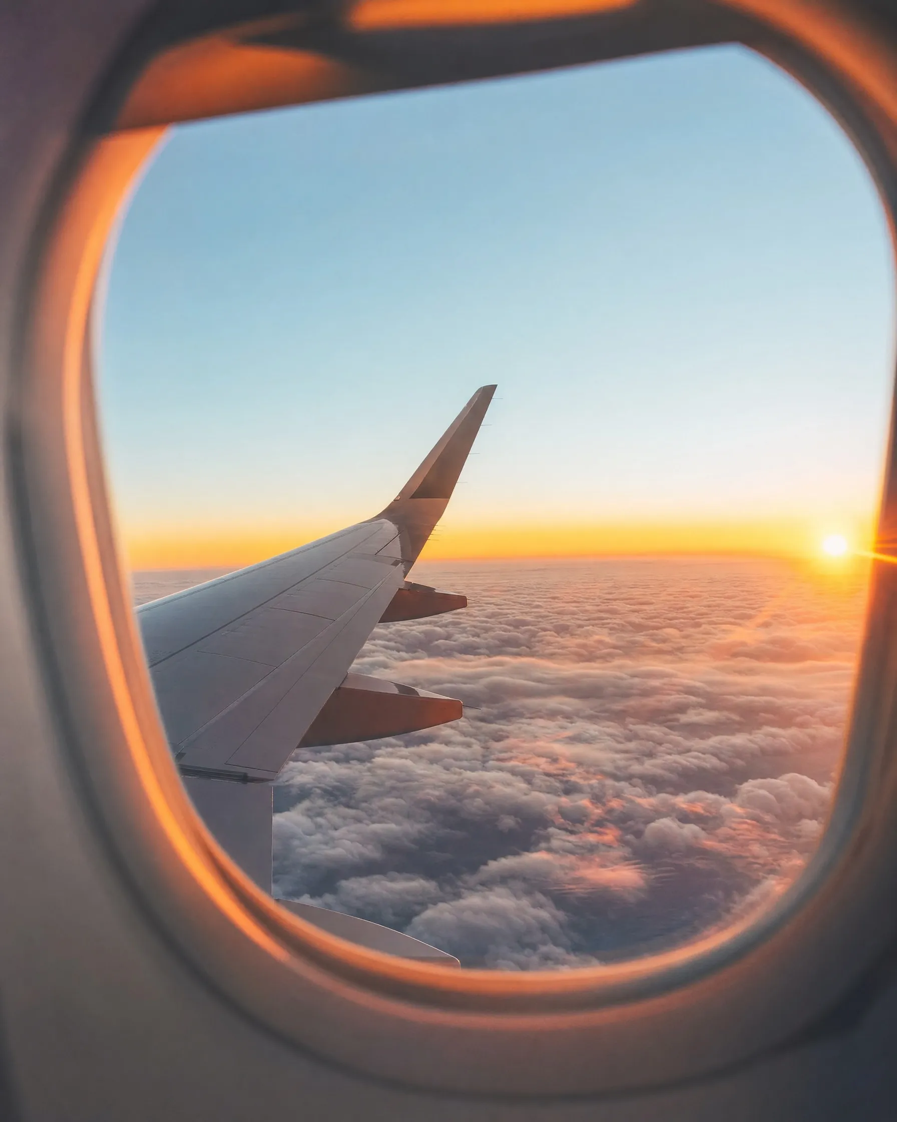 A plane wing over clouds seen from a window seat