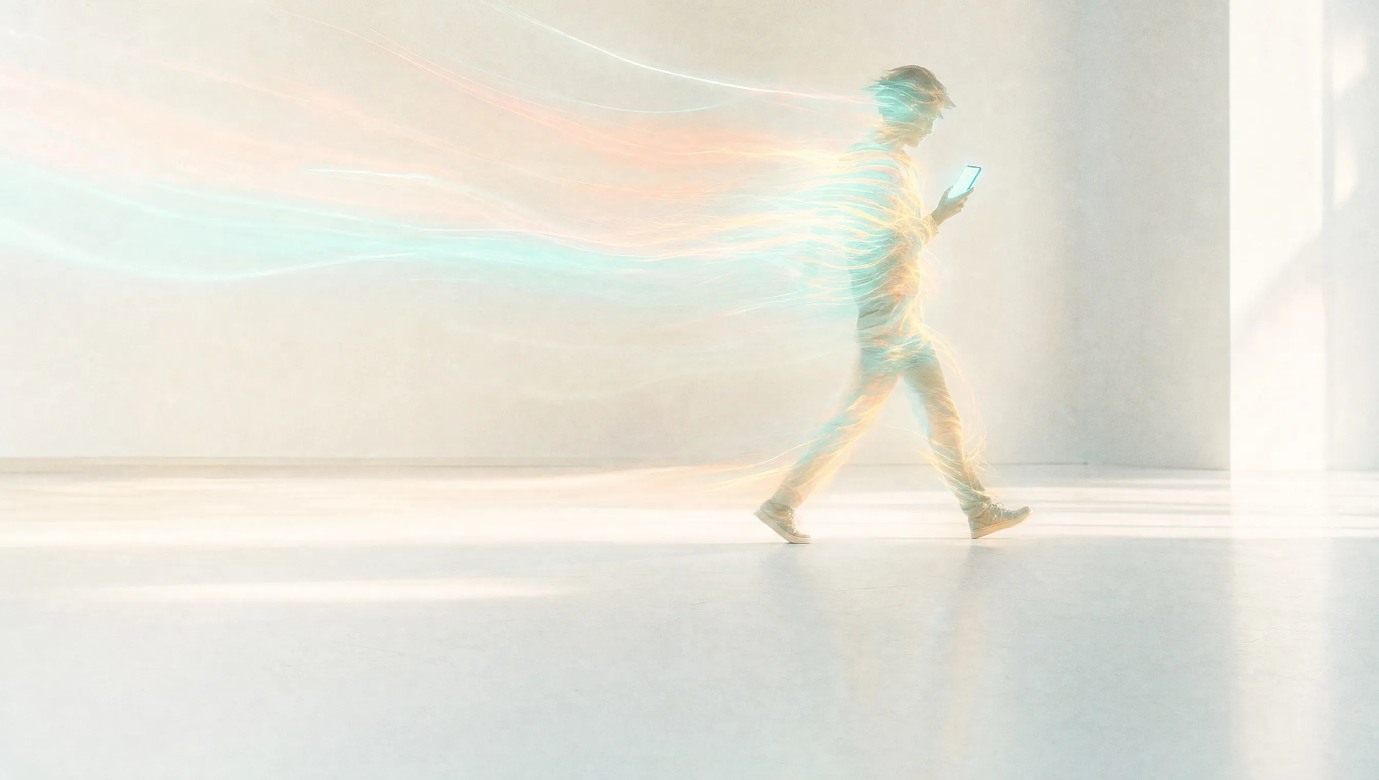 A person walking through a bright, pale room and looking at a phone with a blank, glowing screen, their body dissolving into long-exposure light trails of teal, coral and yellow, like a buyer asking the kind of question answer engine optimisation is written for