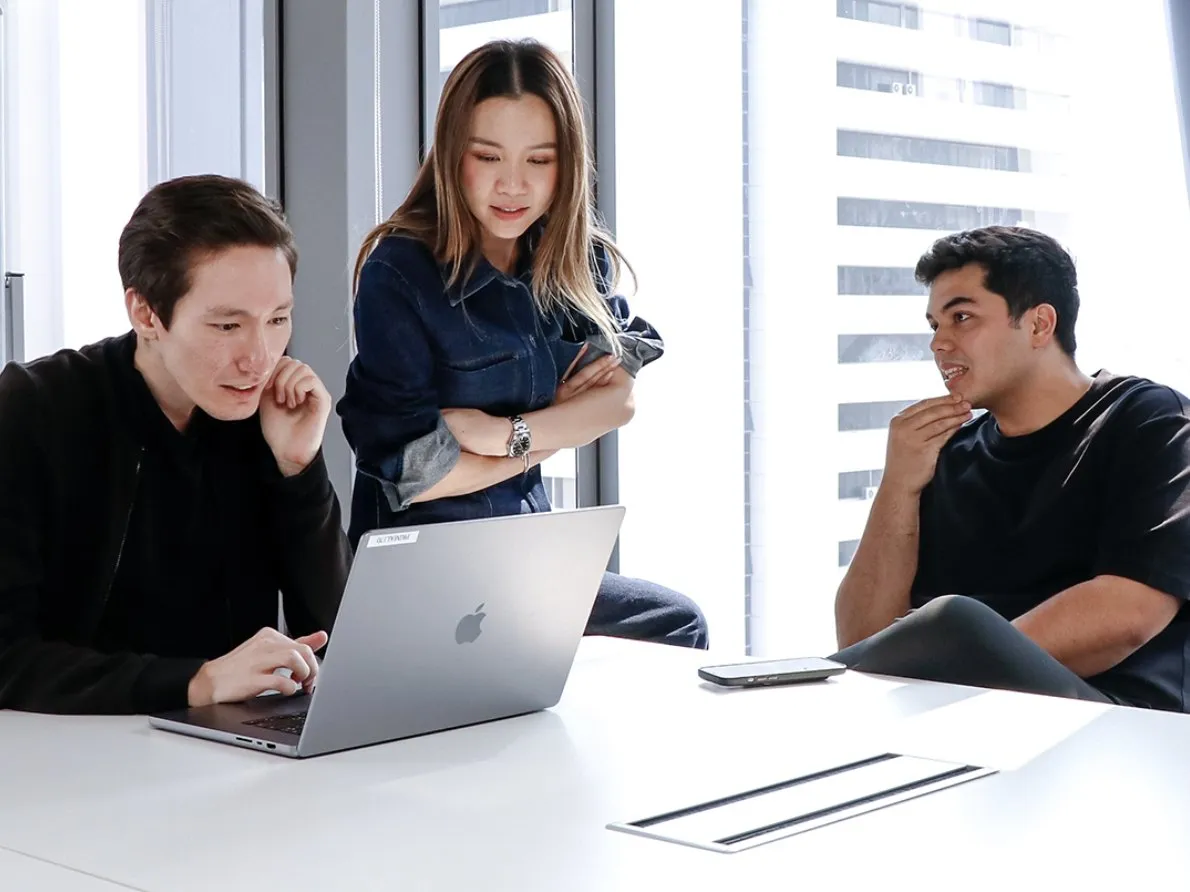 Three Primal strategists working through a plan at a laptop