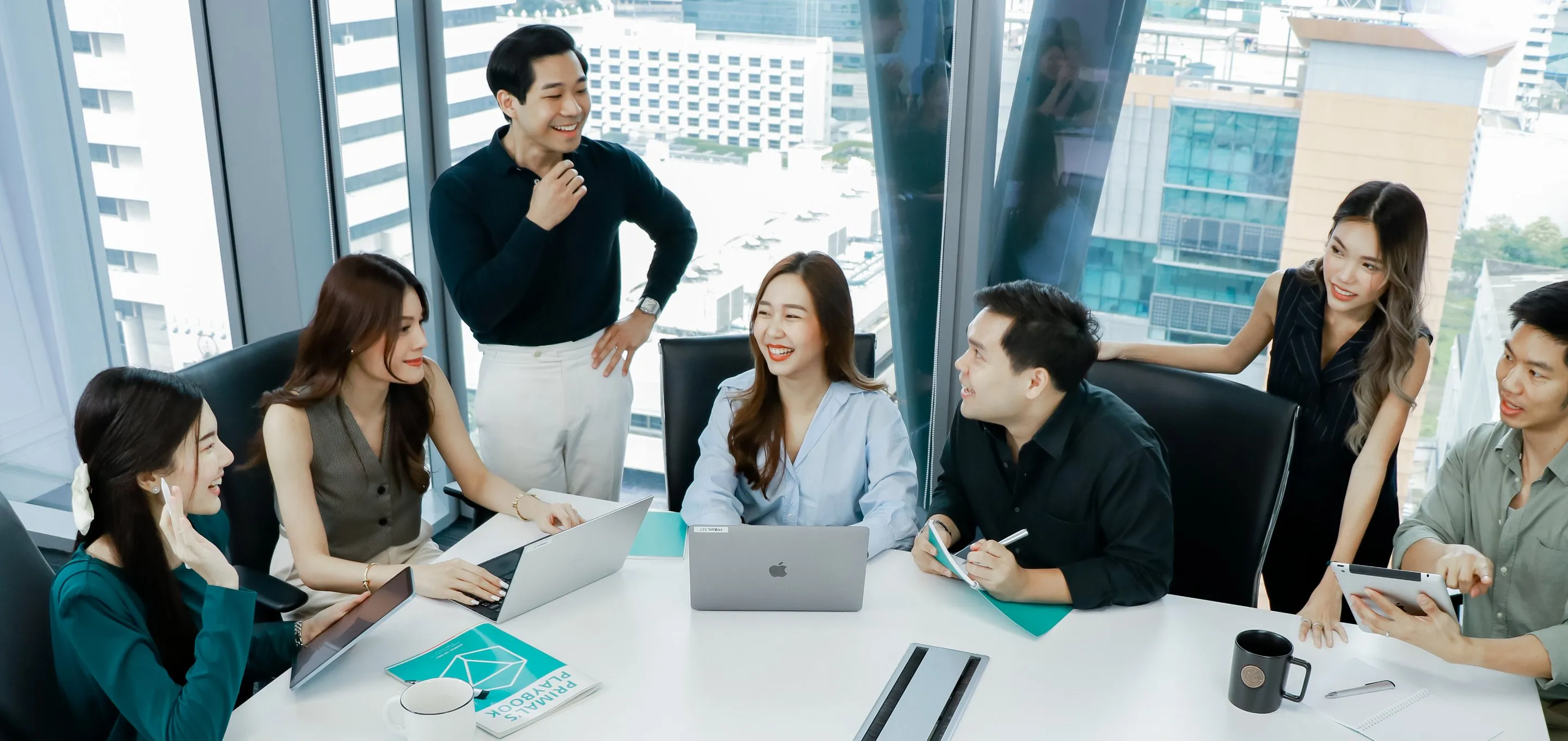 Primal colleagues around a meeting table with their laptops open