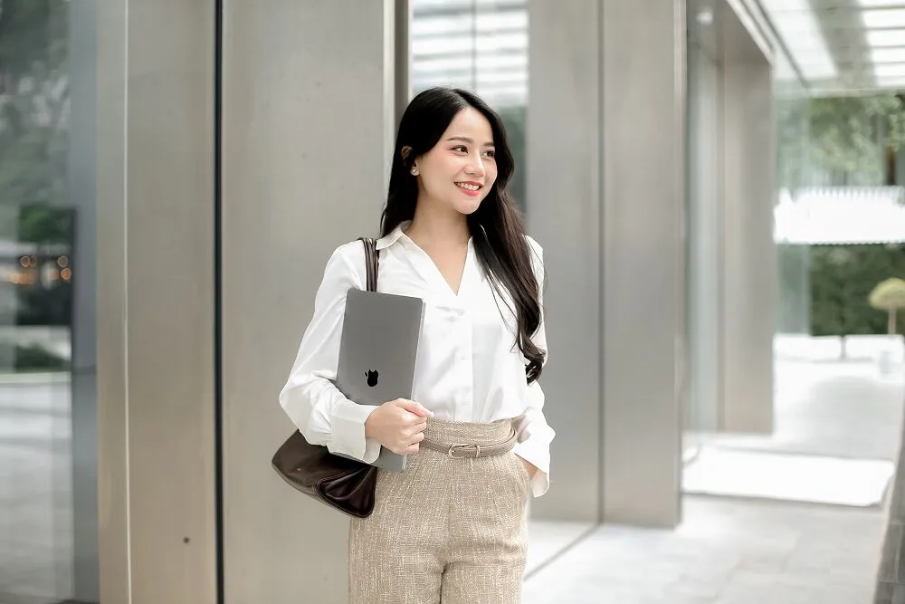 A Primal colleague holding a laptop in an office building lobby
