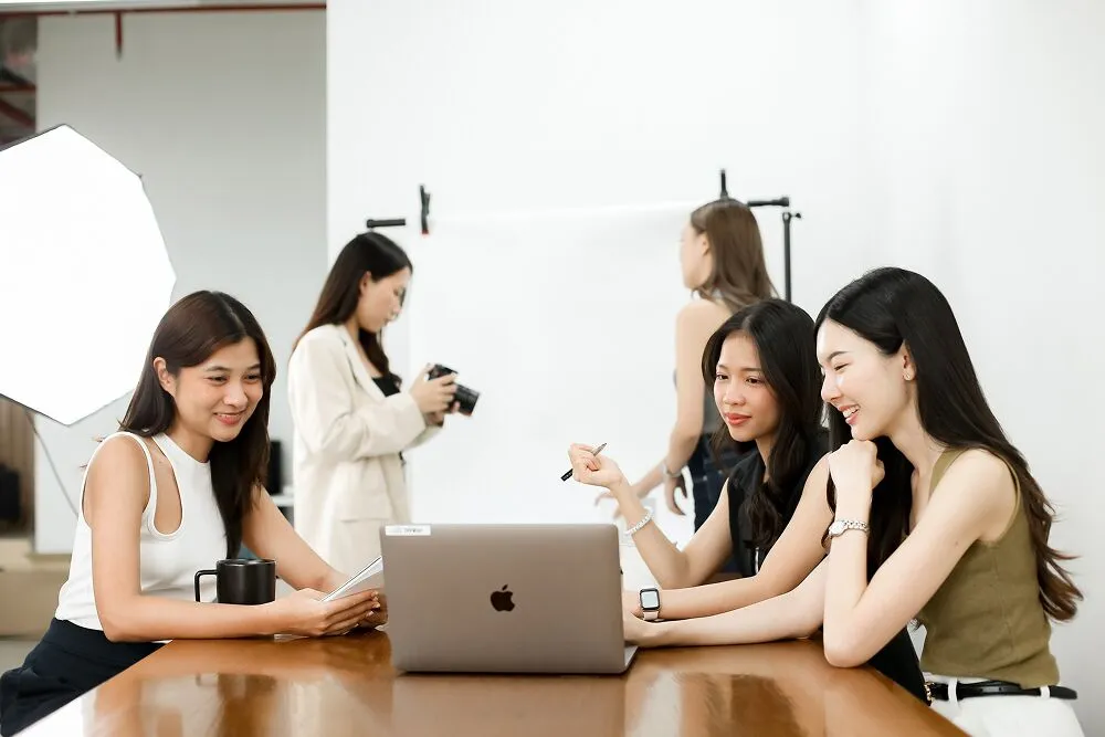 Four Primal colleagues talking around a table with a laptop and a camera